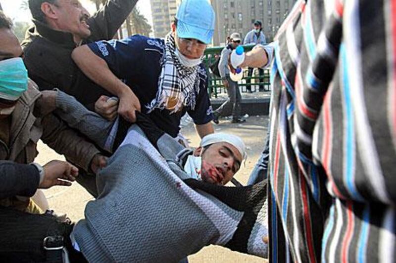 An injured protester is taken way during clashes with Egyptian security forces yesterday.