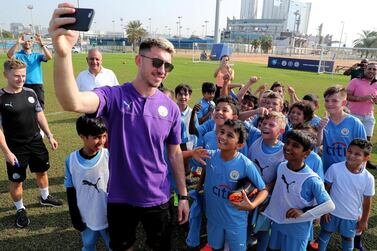 Aymeric Laporte with with students of Manchester City Football School at the Zayed Sports city in Abu Dhabi in 2019. Pawan Singh / The National