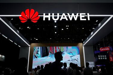 People walk past a Huawei sign board at the 2018 Consumer Electronics Show Asia in Shanghai. Reuters