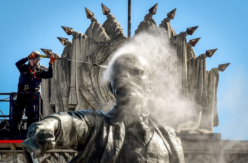 A worker cleans a statue of the founder of the Soviet Union Vladimir Lenin at Moscow Square in Saint Petersburg, Russia. AFP