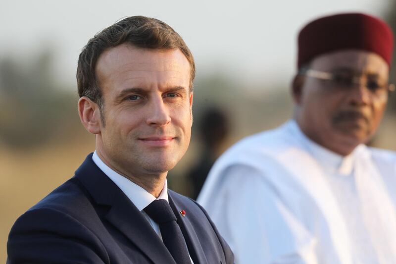 France's President Emmanuel Macron (L) and Niger's President Mahamadou Issoufou (R) take part in a military ceremony at the Martyr Quarter on December 22, 2019, in Niamey, to pay homage to 71 Nigerien soldiers massacred in an attack on December 10 at the Inates military camp in the Sahel country's western Tillaberi region. / AFP / POOL / Ludovic MARIN
