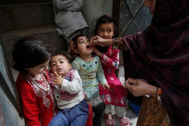 A health worker administers vaccine to a child in Lahore, Pakistan on March 16, 2020 as part of polio eradication campaign that has since been suspended because of the Covid-19 pandemic. AP Photo