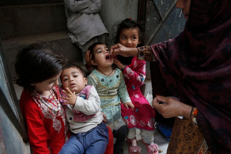 A health worker gives a polio vaccine to a child in Lahore, Pakistan, Monday, March 16, 2020. Pakistan government launched an anti-polio vaccination campaign in an effort to eradicate the crippling disease affected children. (AP Photo/K.M. Chaudary)