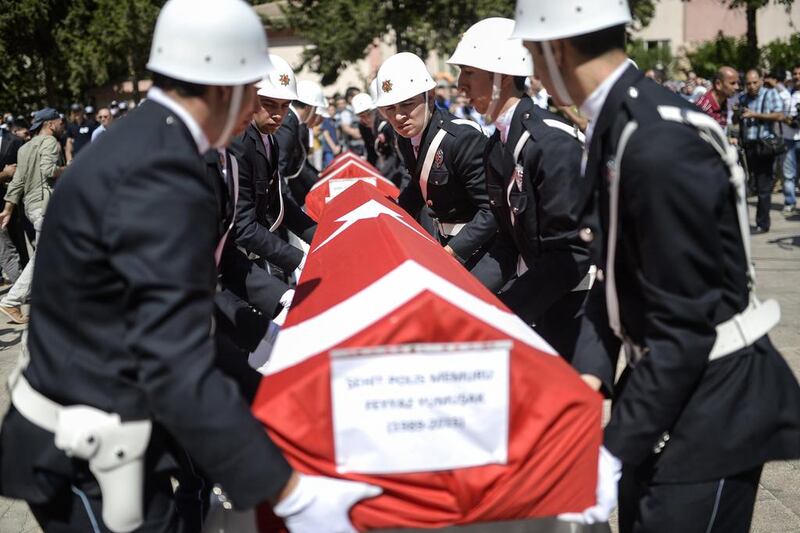 The coffins of two Turkish police officers during their funeral on July 23, in Sanliurfa, after they were found shot dead at their home in the Turkish town of Ceylanpinar on the border with Syria. Bulent Kilic/AFP Photo

