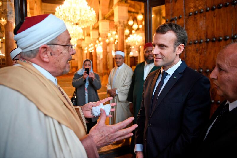 French President Emmanuel Macron (C-R) speaks with a Muslim cleric as he visits the Zitouna mosque in the Medina (old town) of the Tunisian capital Tunis on February 1, 2018, during his first state visit to the North African country. / AFP PHOTO / POOL / Eric FEFERBERG