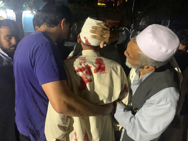 Afghan men carry an injured man in the hospital after a large explosion in Kabul, Afghanistan, Monday, Sept. 2, 2019. Afghan officials say a large explosion the capital, Kabul, has targeted the Green Village compound, home to several international organizations and guesthouses. (AP Photo/Rahmat Gul)