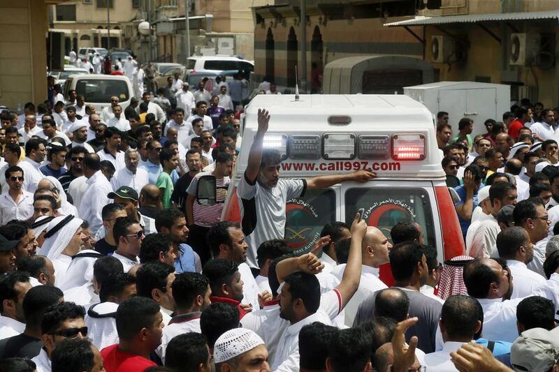 Worshippers gather around an ambulance following the blast.  EPA
