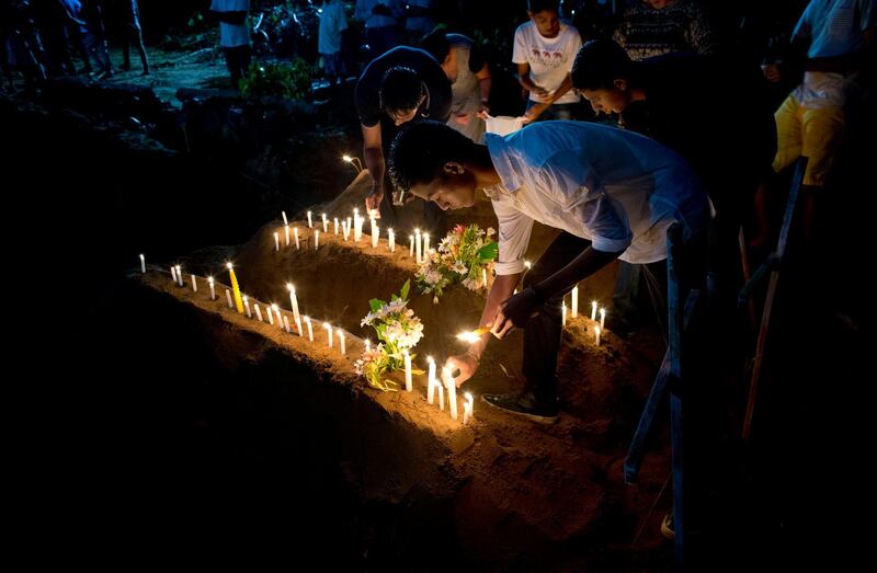 Relatives light candles. AP Photo