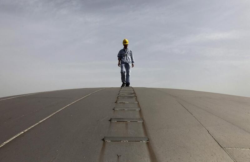 An employee walks on top of an oil tank at a Sinopec refinery in Wuhan, Hubei province. The Chinese oil refiner has been hit hard by the collapse of crude prices. Reuters