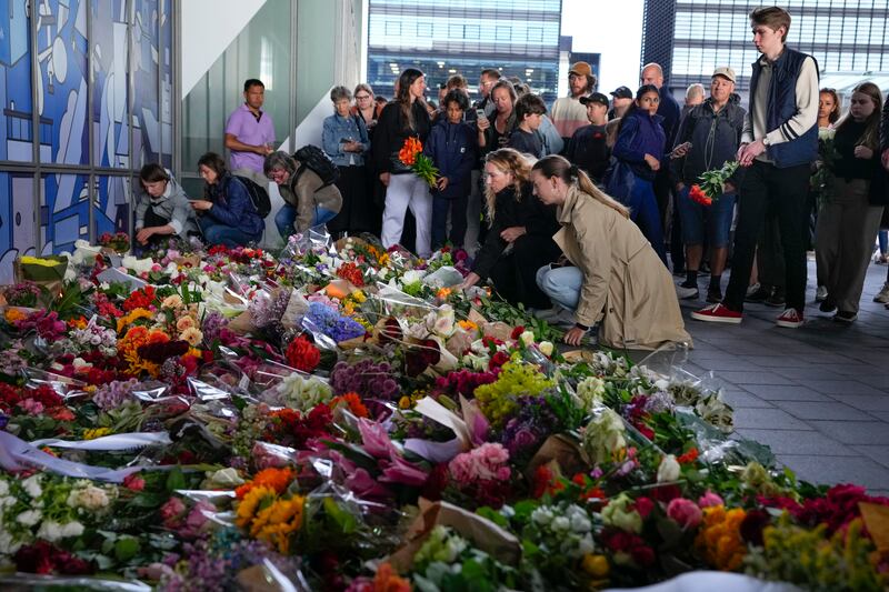 People lay flowers to honour victims killed in a terror attack at a shopping centre in Denmark.  AP Photo