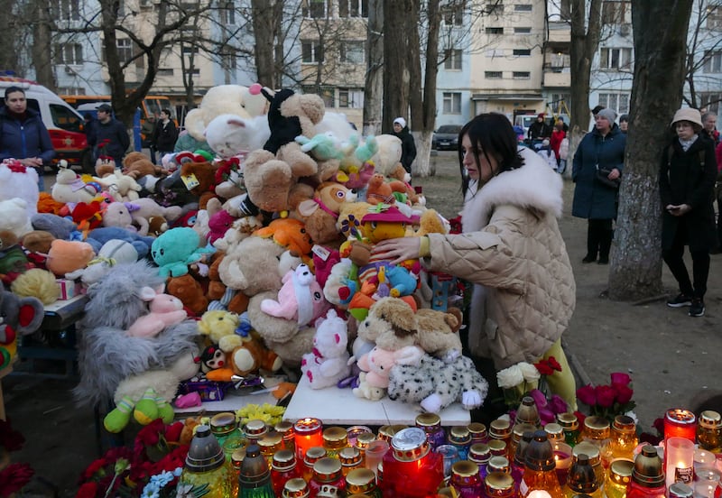 Ukrainians place toys, flowers and candles at a site hit by a Russian drone attack one day earlier, in the southern city of Odesa, Ukraine. The attack killed 12 people, including three children, and wounded eight others. EPA 