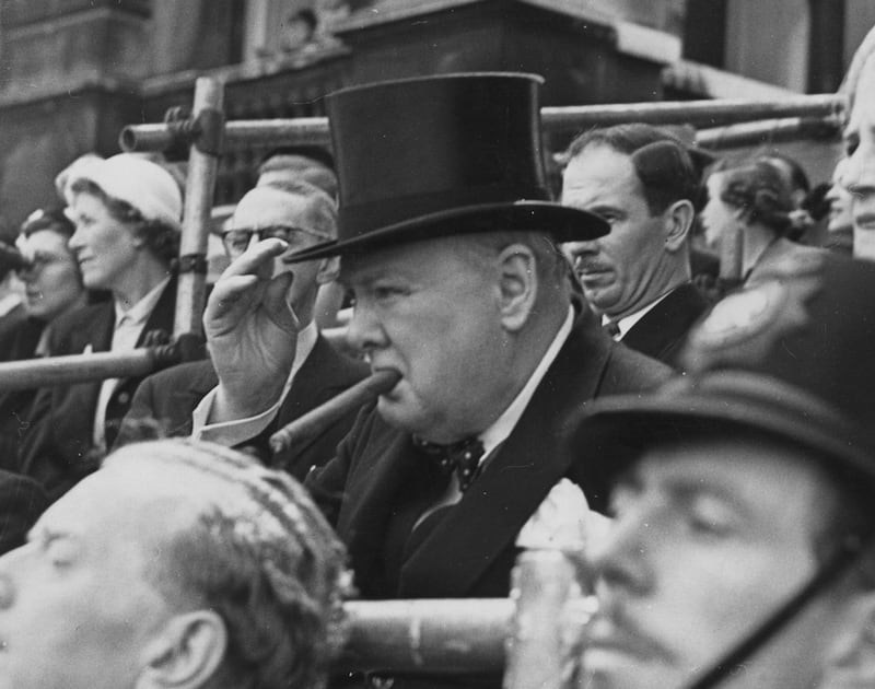 Prime minister Winston Churchill, with his customary cigar, watches the parade in 1952