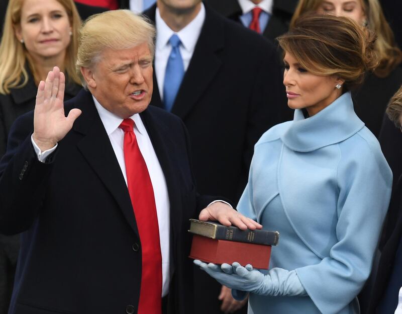 (FILES) In this file photo taken on January 20, 2017, US President-elect Donald Trump, with his wife Melania Trump, is sworn in as President at the US Capitol in Washington, DC. - Melania Trump has courted controversy with everything from her words to her clothes. At times, she has seemed less than enthralled with life in the White House. But come next week, the 50-year-old native Slovenian -- the first foreign-born first lady in two centuries -- might be extending her stay in the East Wing for another four years. Trump, the third wife of her president husband, is a former model with a dazzling gaze who has been a discreet source of support for the US leader, mostly out of the camera frame. (Photo by Mark RALSTON / AFP)