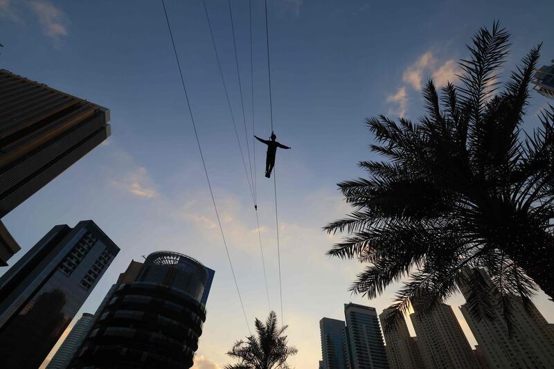 A man slides along a zip line over the Marina