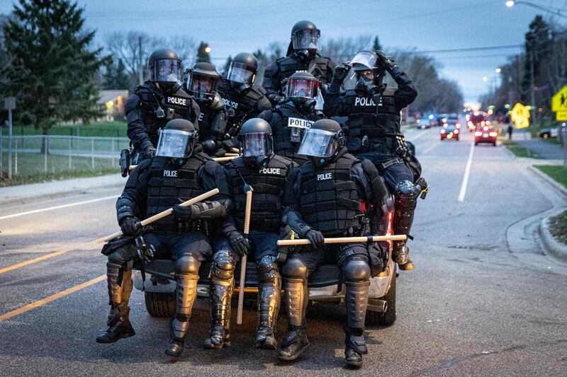 Minneapolis police officers in riot gear leave as protesters gather after an officer allegedly shot and killed a man in Brooklyn Centre, Minneapolis, Minnesota.  AFP
