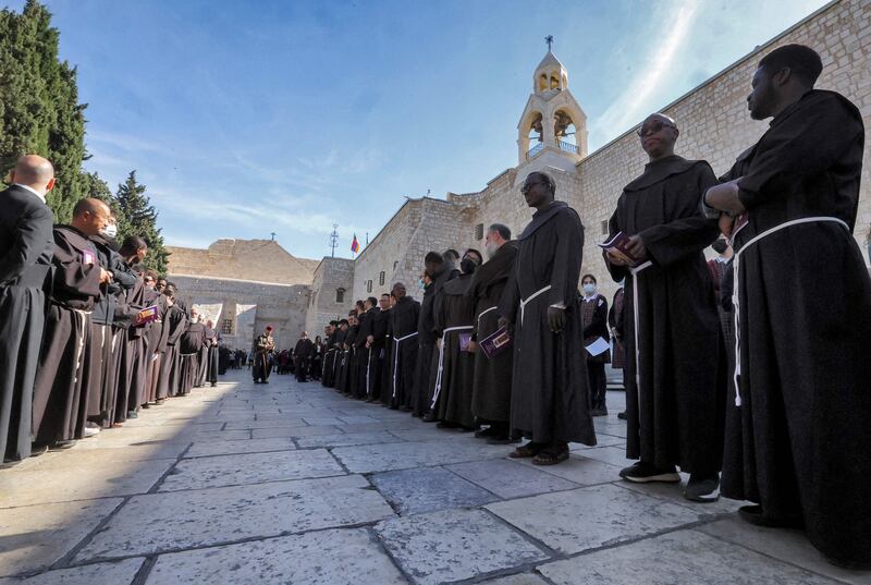 Franciscan monks wait outside the Church of the Nativity in Bethlehem. AFP