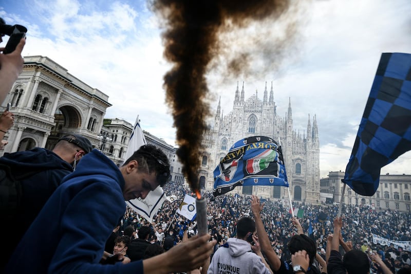 Internazionale supporter holds a smoke canister as they celebrate at Piazza Duomo in Milan after their team won the Serie A title. AFP