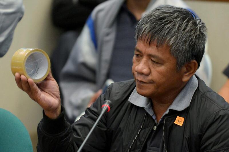 Edgar Matobato, a self-confessed former hitman, holds up a roll of tape of the type he claims he used on his victims, during a September 15, 2016, senate hearing on drug-related extrajudicial killings, in Pasay city  Metro Manila, Philippines. Ezra Acayan / Reuters