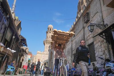 A seller of balady, a traditional Egyptian flatbread, rides his bicycle outside a bakery in Cairo. AP