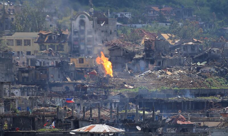 Flame rises as damaged buildings are seen after government troops cleared the area from pro-Islamic State militant groups inside a war-torn area in Marawi city, southern Philippines October 23, 2017. REUTERS/Romeo Ranoco