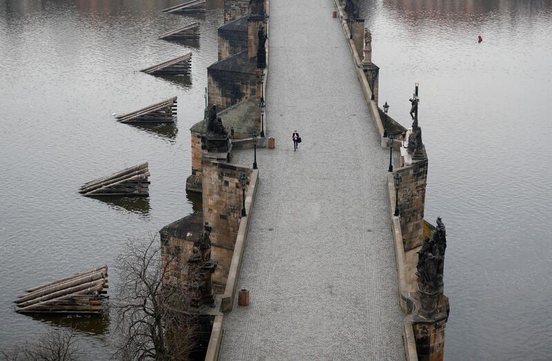 A woman walks across the near empty Charles Bridge in Prague, Czech Republic. AP Photo