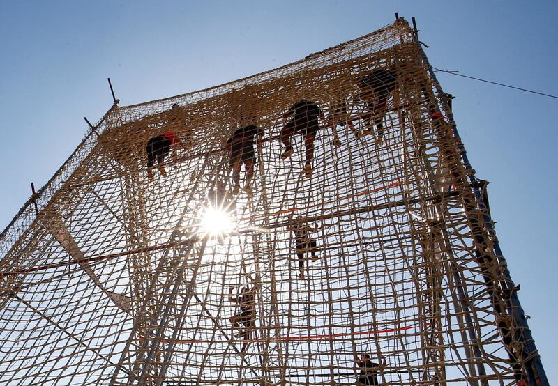 Competitors scale a net at Egypt's Tough Mudder challenge, organised by TriFactory, an Egyptian sports management company, at the O West district, in Giza. Reuters