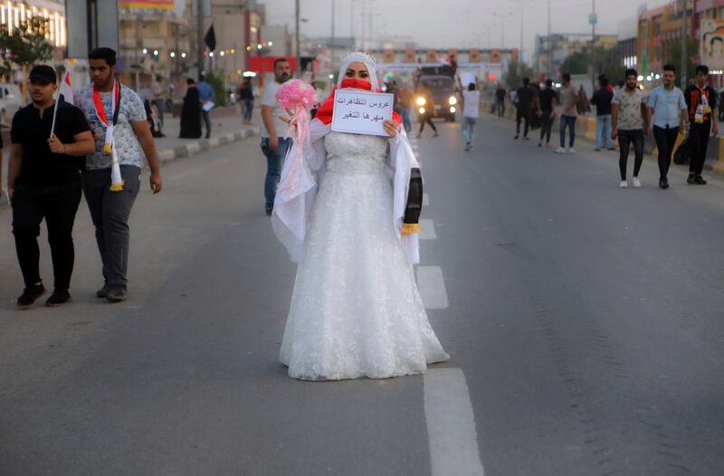 A woman wearing a wedding dress holds a placard with an Arabic sentence reads "the Bride of the demonstrations, her dowry is the change" takes part in the ongoing protests in Basra, Iraq. AP Photo