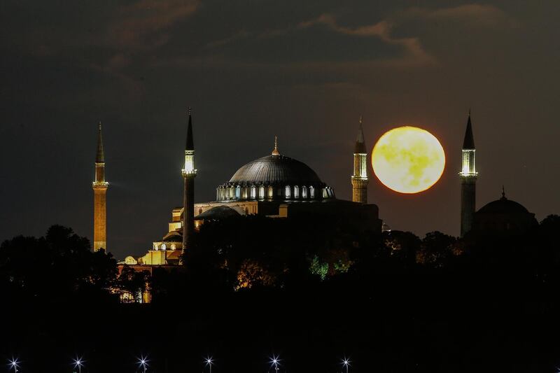 The full moon rises behind the Byzantine-era Hagia Sophia, in the historic Sultanahmet district of Istanbul, early Tuesday, Sept. 1, 2020. Worshipers held the first Muslim prayers in 86 years inside the Istanbul landmark that served as one of Christendom's most significant cathedrals, a mosque and a museum before its conversion back into a Muslim place of worship on July 24, 2020. The conversion of the edifice, has led to an international outcry.(AP Photo/Emrah Gurel)