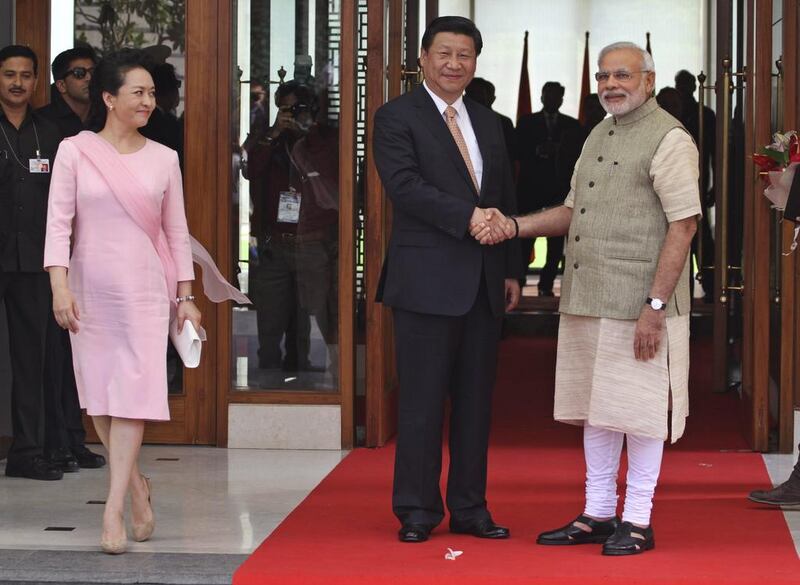 Indian Prime Minister Narendra Modi, right, poses with Chinese President Xi Jinping as he welcomes him upon his arrival at a hotel in Ahmadabad, India, Wednesday, Sept. 17, 2014. Xi’s wife Peng Liyuan is on left. Xi landed in Modi’s home state of Gujarat on Wednesday for a three-day visit expected to focus on India's need to improve worn out infrastructure and reduce its trade deficit. (AP Photo/Ajit Solanki)
