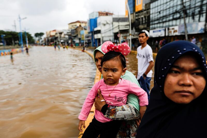 Locals look on after floods hit Jatinegara. Reuters