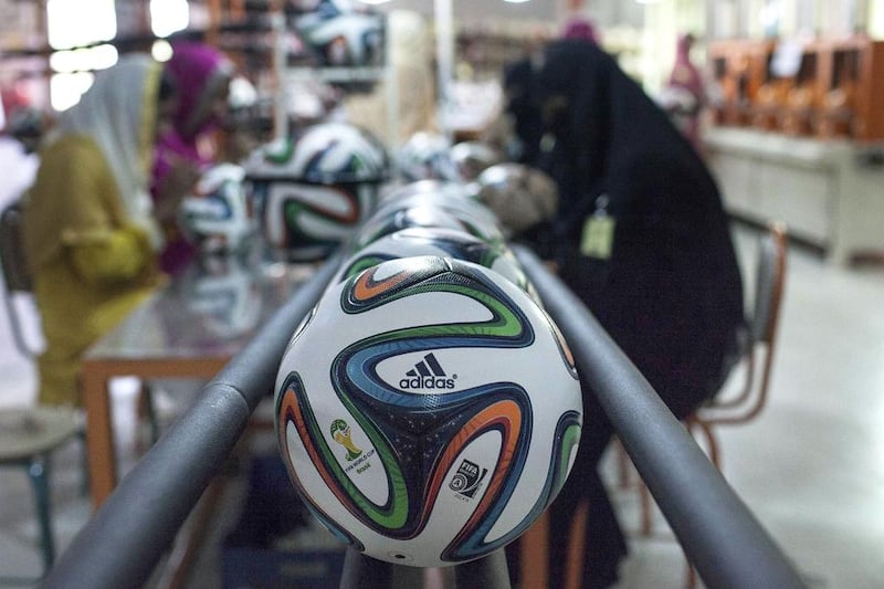 Employees work near official 2014 World Cup balls at the final stage of their quality check inside the football factory that produces official match balls for the World Cup in Brazil, in Sialkot, Punjab province. Sara Farid / Reuters

