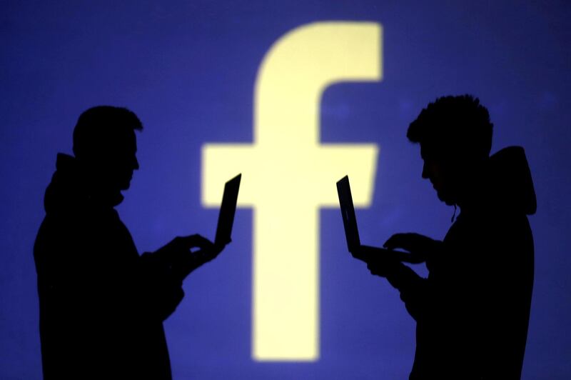 FILE PHOTO: Silhouettes of laptop users are seen next to a screen projection of Facebook logo in this picture illustration taken March 28, 2018.  REUTERS/Dado Ruvic/File Photo/File Photo