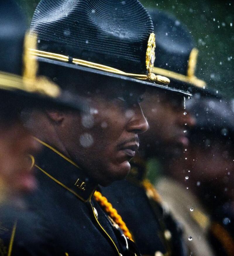 A honour guard stands at attention in the rain at the funeral service for police officer Timothy Smith in Georgia, United States. Woody Marshall / The Macon Telegraph via AP Photo
