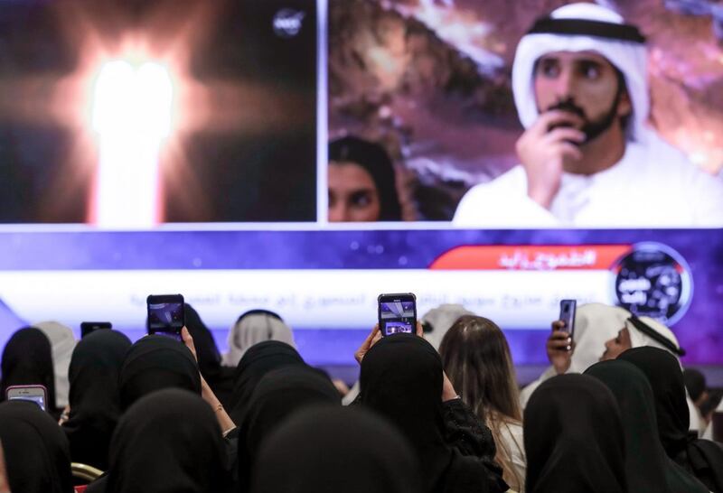 Sheikh Hamdan bin Mohammed, Crown Prince of Dubai, watches the launch at Mohammed bin Rashid Space Centre, while people at Adnec film the moment the rocket blasts off. Victor Besa / The National 
