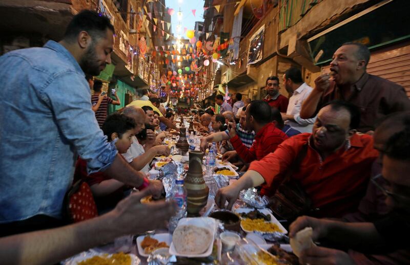 Residents of Ezbet Hamada in Cairo's Mataria district gather for iftar. EPA