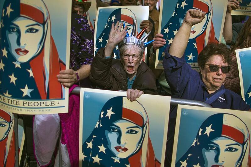 People carrying posters at a rally against President Donald Trump's executive order banning travel from seven Muslim-majority nations, in New York's Times Square on February 19, 2017. Andres Kudacki/AP Photo