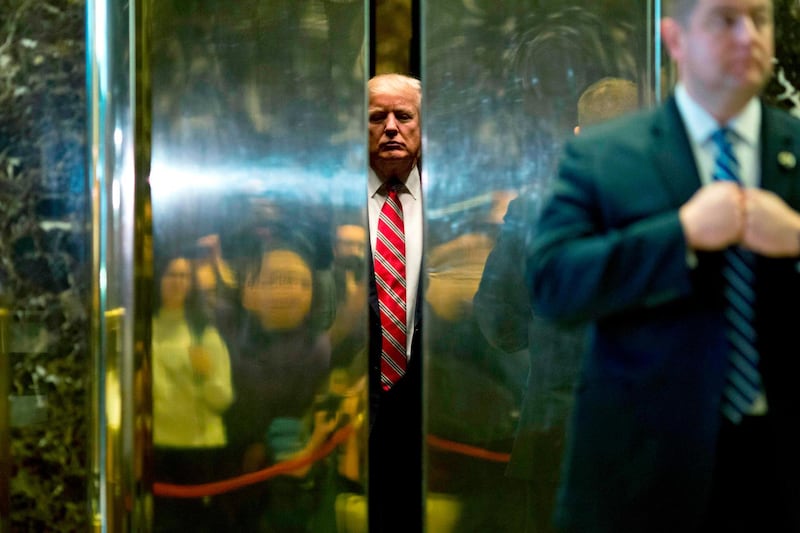 US president Donald Trump boards the elevator after escorting Martin Luther King III to the lobby after meetings at Trump Tower.  Dominick Reuter / AFP Photo / January 16, 2017