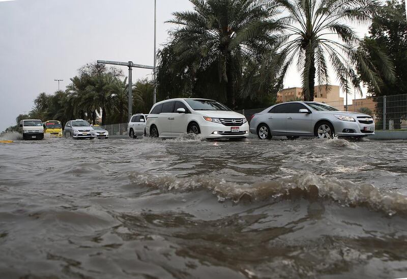 Drivers negotiate a flooded road in Abu Dhabi. Ravindranath K / The National