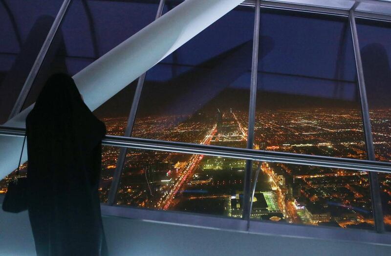 A Saudi woman looks out over the skyline view of Riyadh from the 99th floor – the viewing floor – at The Kingdom tower. Jordan Pix / Getty Images