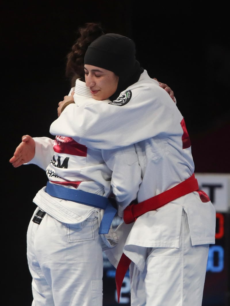 Jessa Khan (L) of Cambodia embraces Mahra Alhinaai (R) of United Arab Emirates after the women's 49 kg Ju-Jitsu gold medal match of the 18th Asian Games Jakarta. EPA