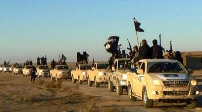 FILE - In this undated file photo released online in the summer of 2014 on a militant social media account, which has been verified and is consistent with other AP reporting, militants of the Islamic State group hold up their weapons and wave its flags on their vehicles in a convoy on a road leading to Iraq, in Raqqa, Syria. A military spokesman said Monday, Dec. 3, 2018 that the U.S.-led coalition has targeted a senior member of the Islamic State group who was involved in the 2014 killing of American aid worker Peter Kassig. (Militant photo via AP, File)