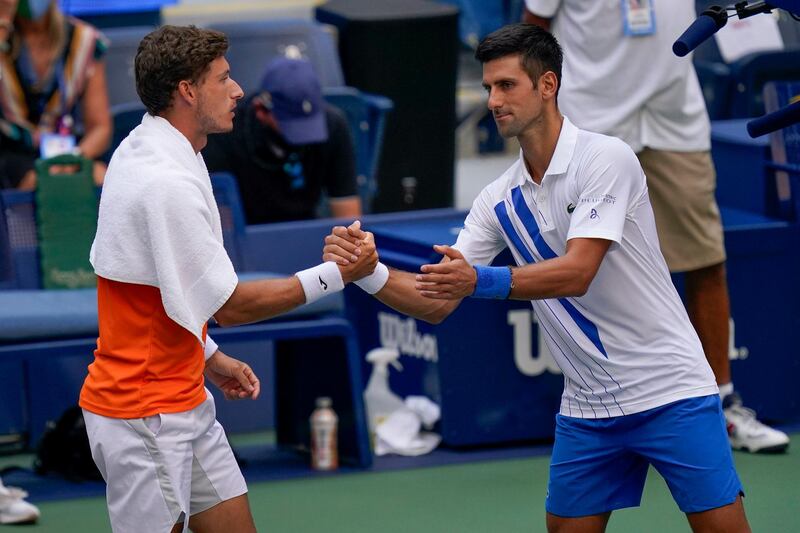 Novak Djokovic shakes hands with Pablo Carreno Busta after the Serb's disqualification. PA