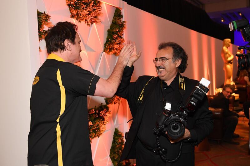 Director Quentin Tarantino high-fives a photographer. AFP