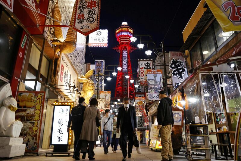 Pedestrians wearing protective face masks in front of the Tsutenkaku Tower in Osaka, Japan. Reuters