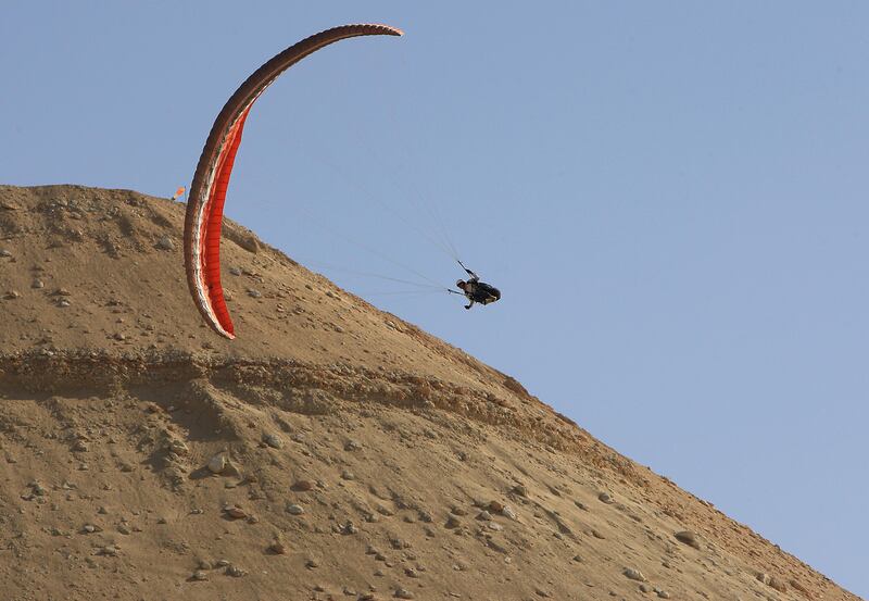 ABU DHABI - UNITED ARAB EMIRATES - 16FEB2013 - Shoaib Ahmedjan paraglider glides down from a 600m-high manmade hill at Al Wathba area outside Abu Dhabi. Ravindranath K / The National