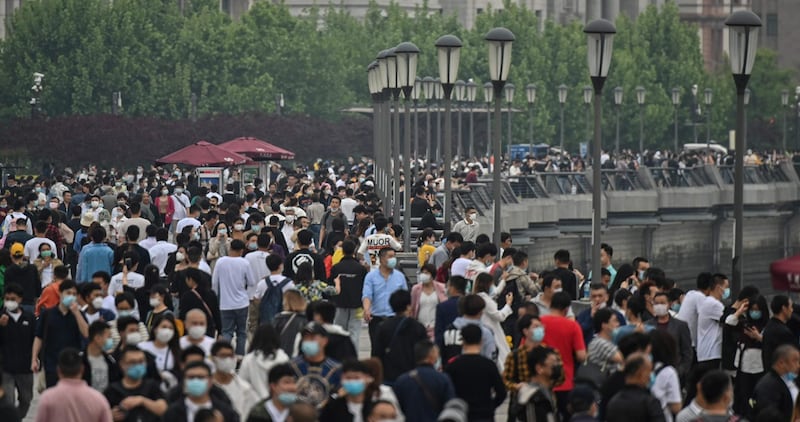 People wearing face masks visit the promenade on the Bund along the Huangpu River during a holiday on May Day, or International Workers' Day, in Shanghai. AFP