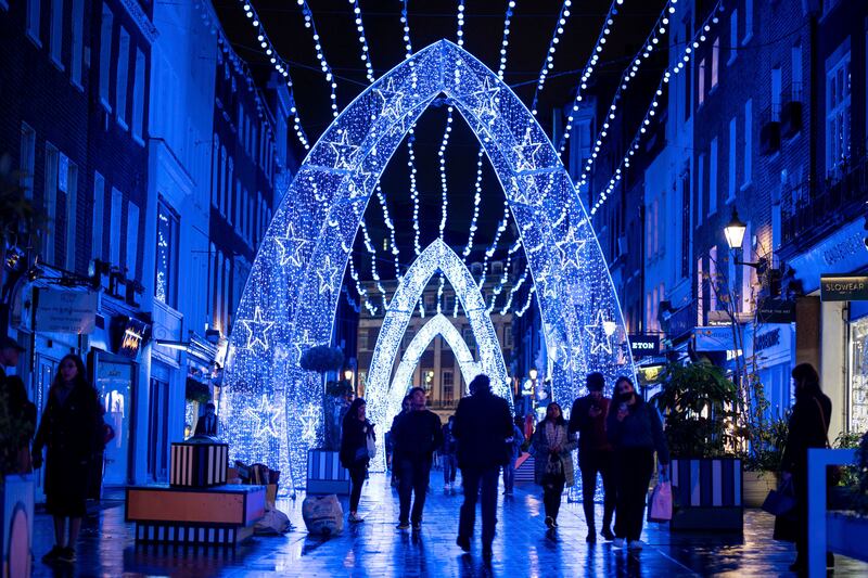 People walk among Christmas lights on South Molton Street, London.