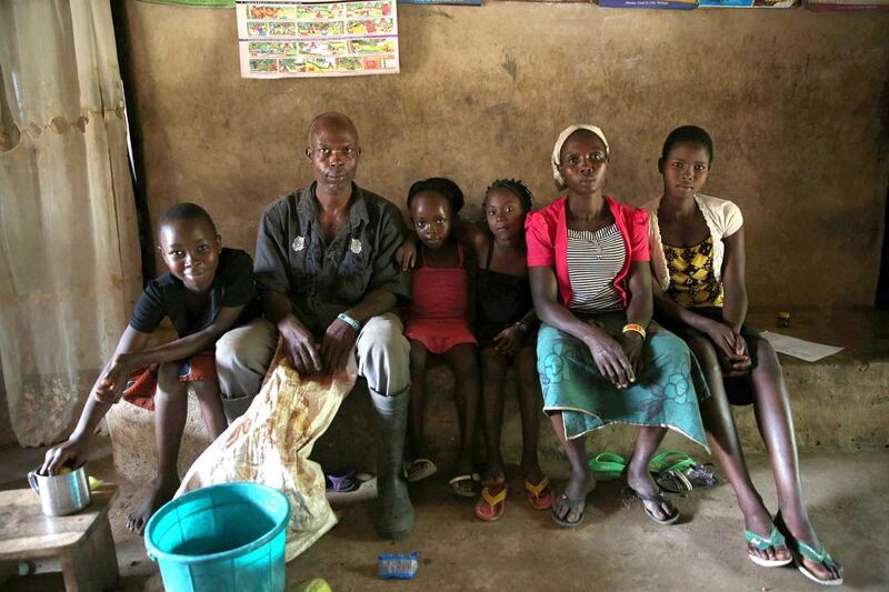 A cocoa farmer and log merchant, Olawole Samson, second left, with his family in their home in the village of Igbatoro, southwest Nigeria. Mr Samson is a community school teacher but also has an expansive cocoa farm where available trees are cut down and sold to support his meagre income. Akintunde Akinleye / Reuters