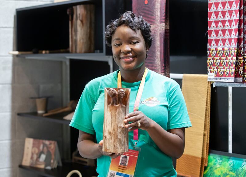 Odette Camacho pictured with some of the hand carved sculptures on sale at the Mozambique Pavilion.
