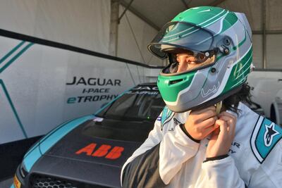 Saudi Arabia's first female race driver Reema al-Juffali fastens her helmet in front of her car during an interview with AFP in Diriyah district in Riyadh on November 20, 2019, ahead of the international Jaguar I-PACE eTROPHY series for electric zero-emission cars set for the weekend. (Photo by FAYEZ NURELDINE / AFP)